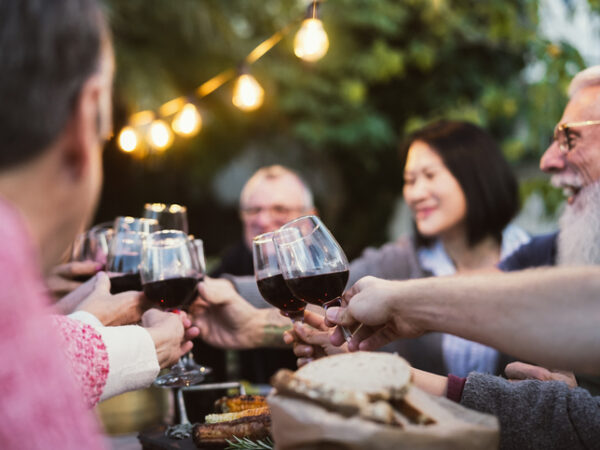 Group of older adults toasting with red wine