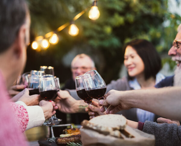 Group of older adults toasting with red wine