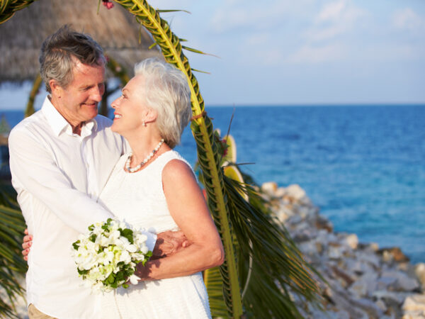 Older man and woman getting married at a beach