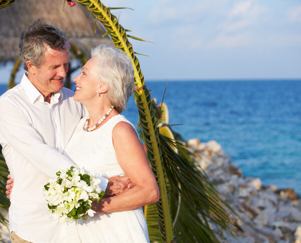 Older man and woman getting married at a beach