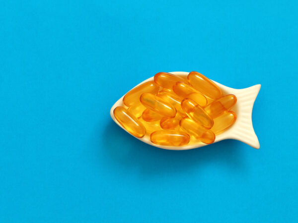 A dish shaped like a fish filled with fish oil supplements
