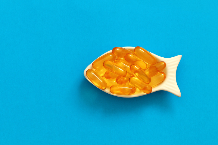 A dish shaped like a fish filled with fish oil supplements
