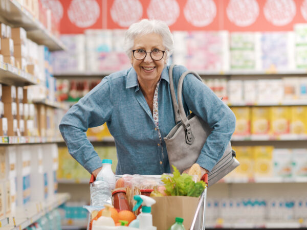 Smiling senior woman shopping at grocery store