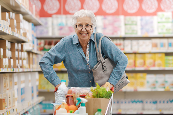Smiling senior woman shopping at grocery store