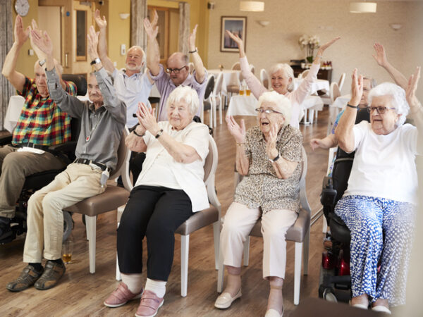 Group of older adults doing seated exercises.