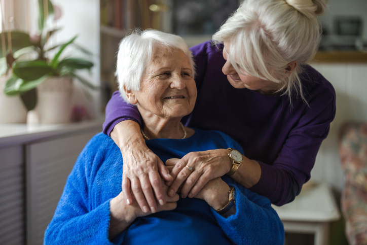 Older woman hugging her elderly mother