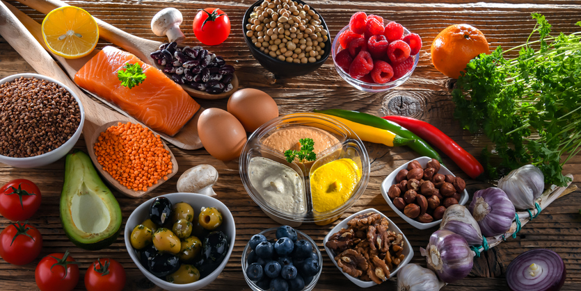 A selection of foods such as salmon, vegetables, nuts and olives that are essential to the Mediterranean diet.