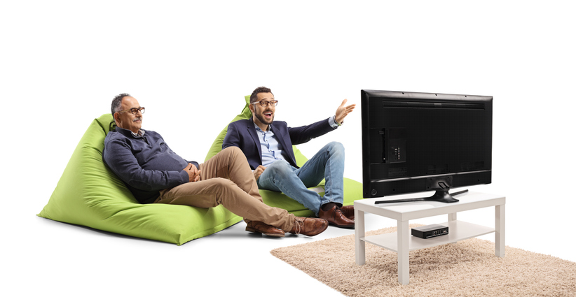 young man and older man sitting on bean bag chairs in front of the tv