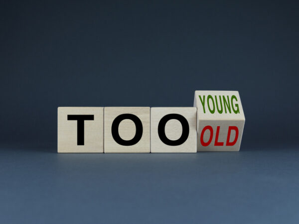 Three cubes with the letters t, o and o and the fourth cube showing the word young as it begins to flip to the word old