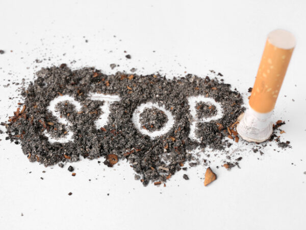 Cigarette ash with the word STOP scrawled in the middle and a cigarette stub on the right side.